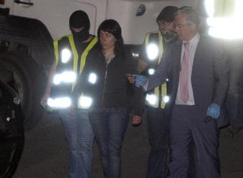 Dos agentes conducen a una detenida en presencia del juez de la Audiencia Nacional Baltasar GarzÃ³n.- EFE